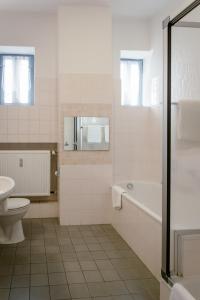 een badkamer met een bad, een toilet en een wastafel bij Hotel Handelshof in Bünde