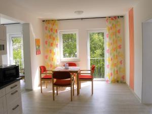 a dining room with a table and chairs and windows at Ferienwohnung im Haus "Maria Anna" in Bad Ems