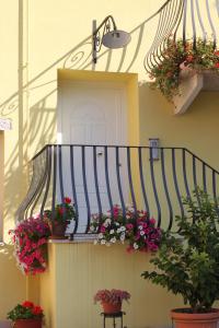 balkon z kwiatami i roślinami na domu w obiekcie B&B Corte Barbieri w mieście Dolcè
