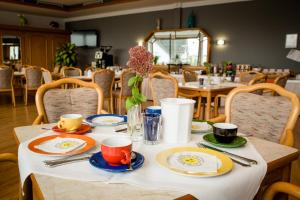 einen Tisch mit Tellern und Tassen darauf in einem Restaurant in der Unterkunft Hotel Handelshof in Bünde