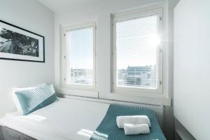 1 dormitorio con 1 cama blanca y 2 ventanas en Forenom Aparthotel Helsinki Kamppi - contactless check-in, en Helsinki