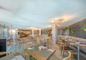 een restaurant met tafels en stoelen in een kamer bij Hotel LIVVO Koala Garden in Maspalomas