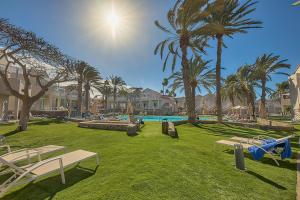 a park with palm trees and a swimming pool at Hotel LIVVO Koala Garden in Maspalomas