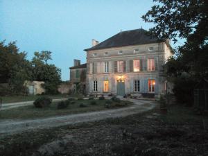 ein altes Haus mit eingeschaltetem Licht in der Unterkunft Le Dojo du Plessis in Mareuil