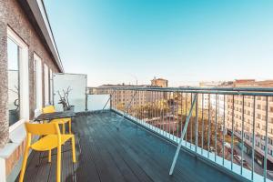 a balcony with yellow chairs and a view of the city at Forenom Aparthotel Helsinki Kamppi - contactless check-in in Helsinki