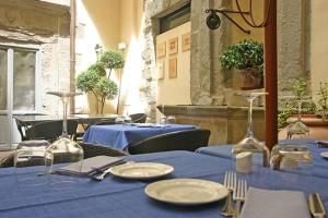 een groep tafels met blauwe tafelkleden en zilverwerk bij Dolce Maria in Cortona