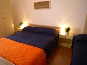 a bedroom with two beds and two night stands with lights at Condominio Alto Adriatico in Grado