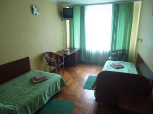 Cette chambre comprend 2 lits et une fenêtre. dans l'établissement RP hotel Лісова пісня, à Kovel