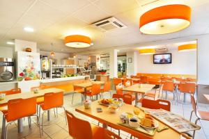 une salle à manger avec des tables et des chaises dans un restaurant dans l'établissement First Inn Hotel, à Apt