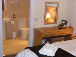 a bathroom with a bed and a sink and a toilet at Schiehallion Hotel in Aberfeldy +20 photos