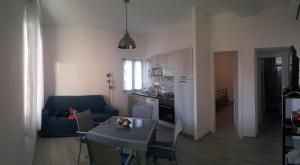 a kitchen and living room with a table and a blue couch at Casa del Geco in Rinella