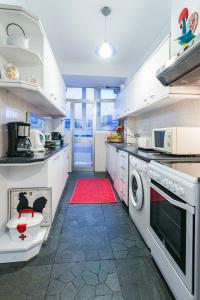 uma cozinha com armários brancos e um tapete vermelho em Apartamento Vintage 1 no Porto