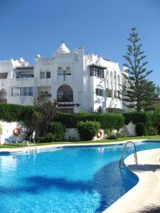 een zwembad voor een groot gebouw bij BLUE Dreams in Mijas