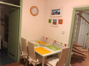 Apartman Paula في بيوغراد نا مورو: غرفة طعام مع طاولة وكراسي وساعة