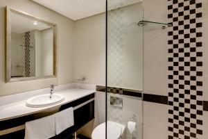 a bathroom with a tub, sink and toilet at Southern Sun The Marine in Port Elizabeth