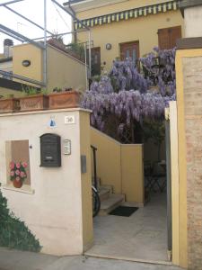 a house with purple wisteria on the side of it at Lo Squero Rooms and Apartments in Fano