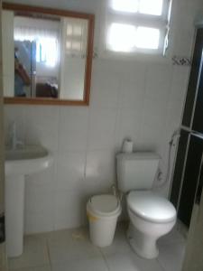 a bathroom with a toilet and a sink and a mirror at Casadateca in Praia Vermelha