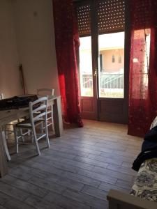 ブルコリにあるLa Casa Accanto il Castelloのリビングルーム(テーブル、椅子、ドア付)