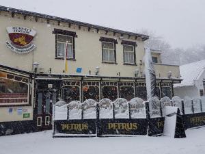a restaurant covered in snow in front of a building at Motel Oostvoorne in Oostvoorne
