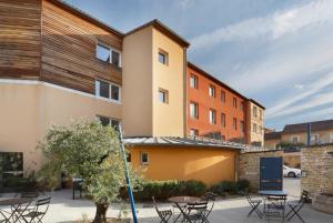 un edificio con mesas y sillas en un patio en Suite Home Apt Luberon en Apt