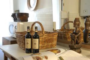three bottles of wine sitting on a table with a basket at Virginias B&B in Savona
