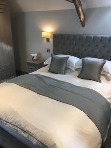a large bed with two pillows on top of it at The Old Malt Scoop Inn in Lapford