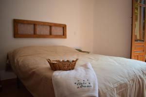 Una cama con una cesta encima. en Hostal Cielo de Gredos, en Guisando