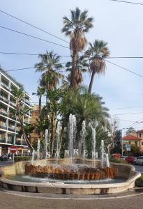 a large fountain with palm trees in a city at Palafiori Rooms Sanremo in Sanremo