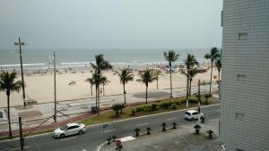 a view of a beach with cars parked on the road at Edificio Edmeia in Praia Grande