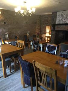 a dining room with wooden tables and chairs at The Old Malt Scoop Inn in Lapford