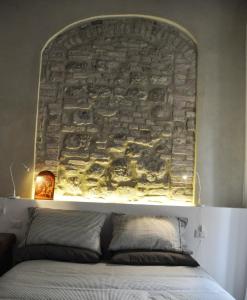 ペルージャにあるOttavianiHouseのベッドの上に石壁のヘッドボード