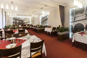 a restaurant with tables and chairs and a fireplace at Arkada Hotel in Bučovice