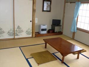 a living room with a coffee table and a television at Morishigesou in Myoko +28 photos