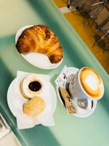 uma bandeja com dois pratos de pastelaria e uma chávena de café em Hotel Casarola - Trigoria em Castel di Decima