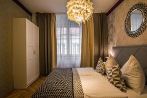 a bedroom with a large bed and a chandelier at Unique Apt 250m from the Charles Bridge in Prague