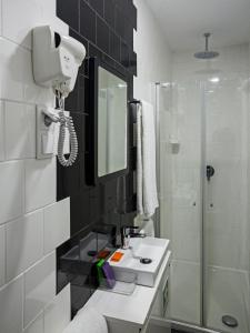 La salle de bains est pourvue d'un lavabo et d'une douche. dans l'établissement Porto Bonjardim Apartments, à Porto