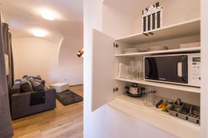 a kitchen and a living room with a microwave at St. Marks Apartment 1 in Zagreb