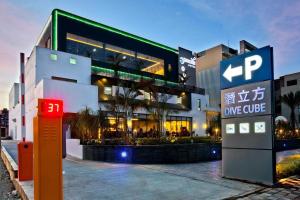 duży budynek z szyldem przed nim w obiekcie Divecube Hotel w mieście Taizhong