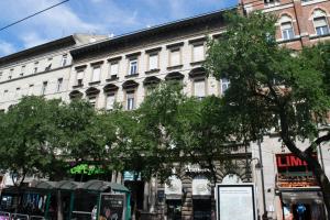 ブダペストにあるElisabeth 21 Apartmentの木々が並ぶ街路の大きな白い建物