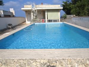 a large blue swimming pool in front of a house at Don Vito in Racale