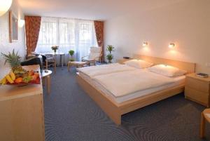 ジンデルフィンゲンにあるHAK ホテル アム クロスターゼーの大きなベッドルーム(大型ベッド1台、テーブル付)