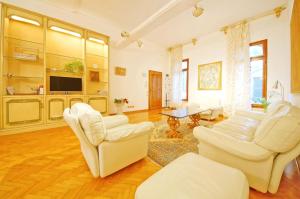 salon z białymi krzesłami i telewizorem w obiekcie DolceVita Apartments N 287 w Wenecji
