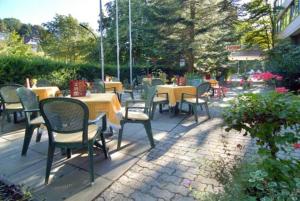 eine Gruppe von Stühlen und Tischen mit Tischen und Stühlen in der Unterkunft HAK Hotel am Klostersee in Sindelfingen