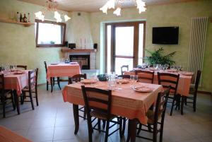 a dining room with tables and chairs and a tv at Agriturismo La Casina in Caprese Michelangelo