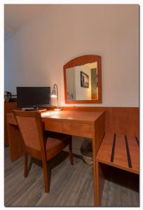 a desk with a mirror and a computer on it at B&B, Brasserie Lakerhof in Ohé en Laak