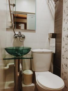 a bathroom with a toilet and a glass sink at Hong Kong Tai San Guest House (Haiphong Branch) in Hong Kong