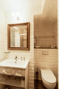 ein Badezimmer mit einem Waschbecken, einem WC und einem Spiegel in der Unterkunft Hotel Restaurant Edmond's in Cap d'Ail