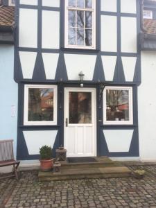 a blue and white building with a white door at Pension Elise in Wolkramshausen