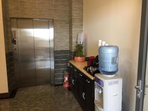 a kitchen with a drink dispenser on top of a refrigerator at De Mei Homestay in Qimei