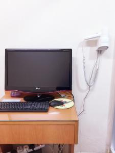 un monitor de ordenador y un teclado y ratón sobre un escritorio en Hong Kong Tai San Guest House (Harilela Branch), en Hong Kong